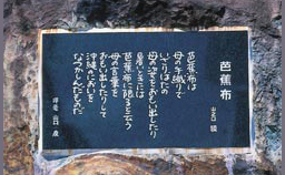 商工会20周年記念に建てられ、黒い石に丸みお帯びた字体で掘られた芭蕉布の碑の写真